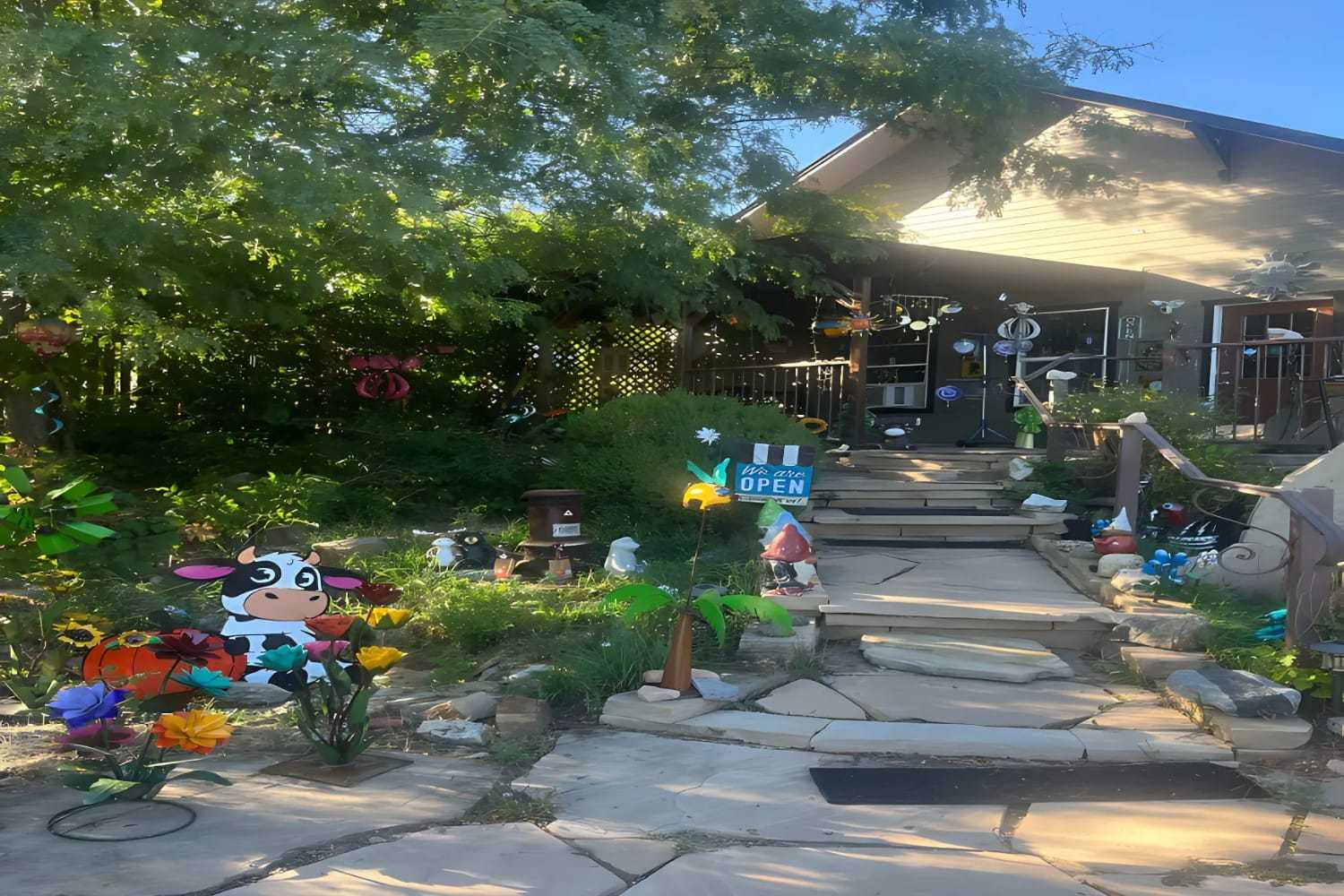 Charming garden shop entrance with whimsical decorations and an "Open" sign.